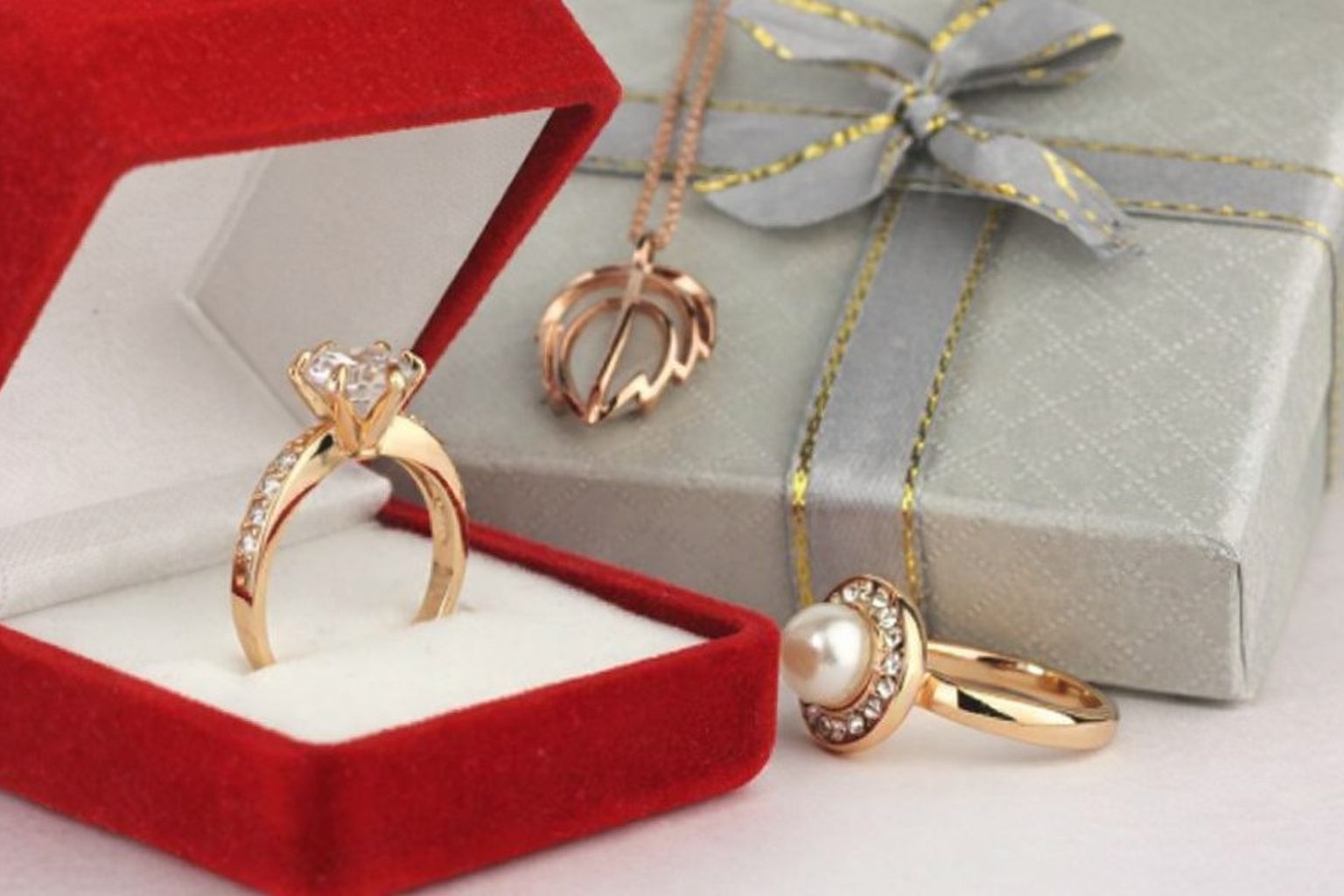 En röd smyckesask med en diamantring och andra smycken, för att visa upp värdefulla föremål.